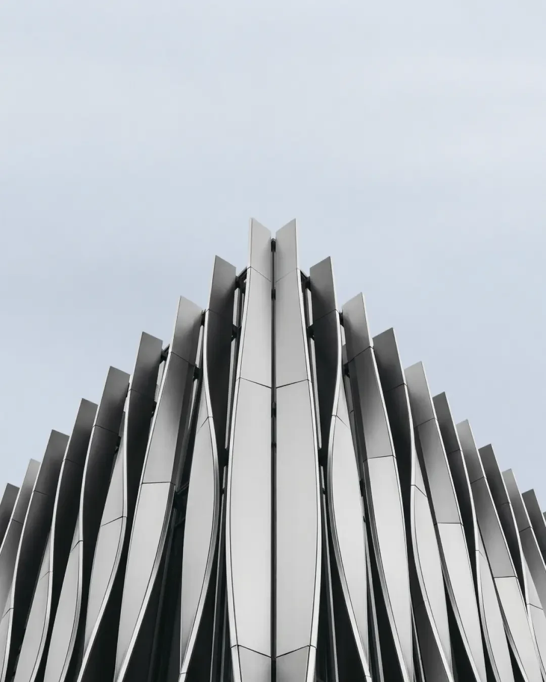 Tall contemporary building facade with symmetrical vertical ribbed panels