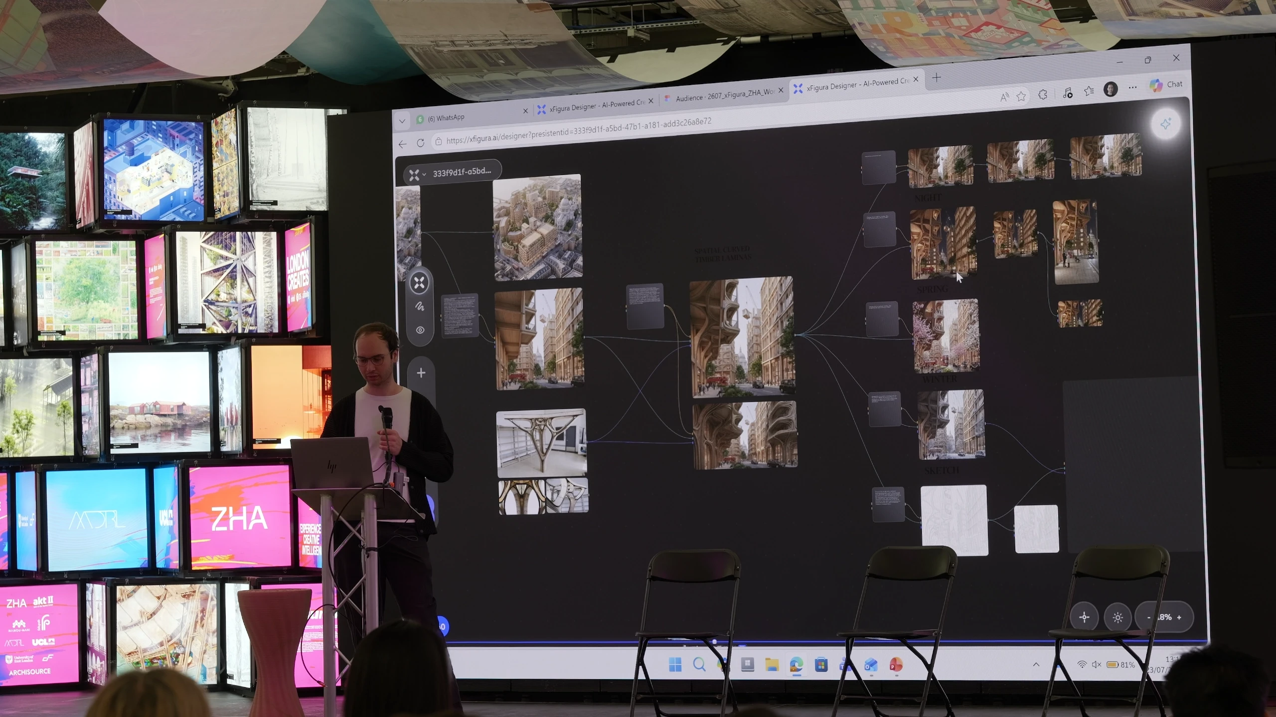 A presenter stands beside a large display screen showing a digital mood board with photographs and architectural images connected by lines, while illuminated panels hang on the wall behind them.